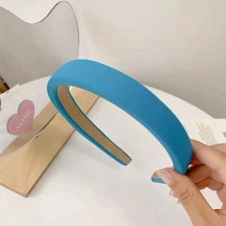 Hand holding royal blue wide sponge headband - vivid blue velvet, wide band width shown