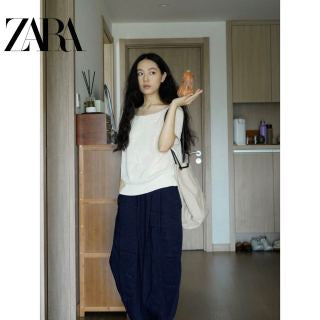 Model wearing navy carrot pants - side profile showing relaxed silhouette