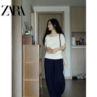 Model wearing navy carrot pants - back view showing tapered ankle fit