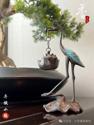 Crane stand with lotus burner hanging - full product display on dark surface with green plants