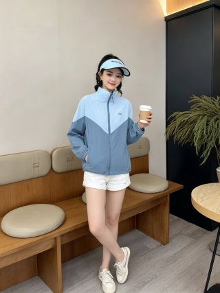 Pink color-block jacket - model seated at cafe table holding coffee