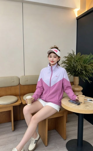 Pink color-block jacket - model seated at cafe table with coffee
