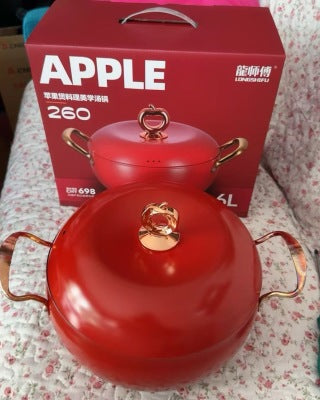 Woman eating from red apple soup pot at dinner table - 6L family meal, lifestyle shot with hot pot