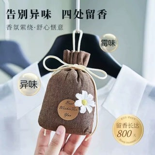 Sachet bag in wardrobe - woman placing sachet among hanging clothes, eliminating odors